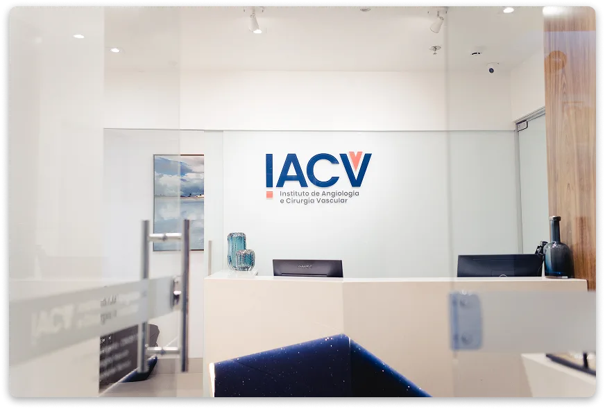 Recepção da clínica IACV, com o logotipo do Instituto de Angiologia e Cirurgia Vascular na parede
